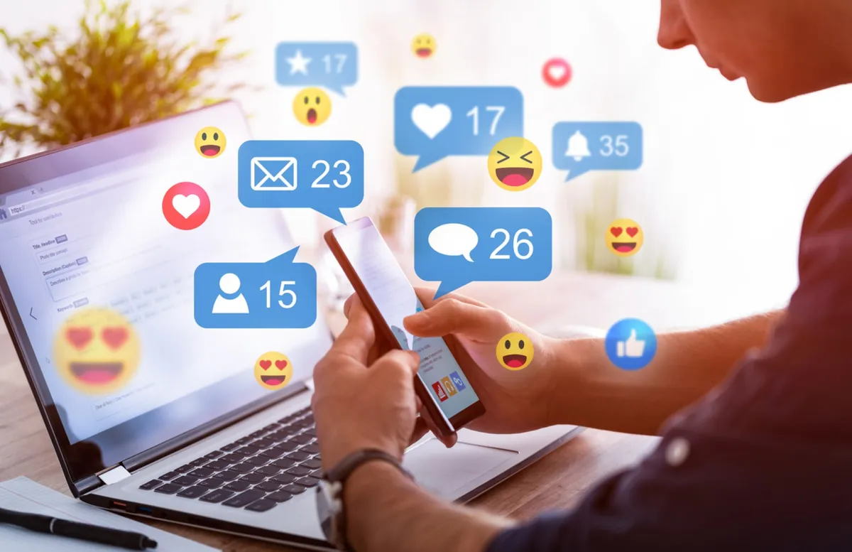 Gestión de redes sociales: persona usando el móvil con notificaciones de mensajes, me gusta y comentarios